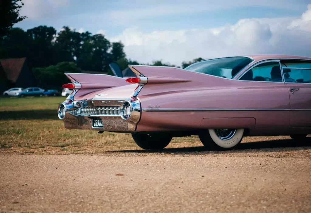 a pink car parked on a dirt road